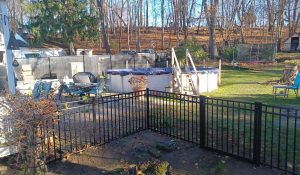 Seasonal Fence Installation: Best Times to Install or Repair Your Fence seasonal metal backyard safety fence installation Black metal backyard safety fence installation around outdoor living and pool area for seasonal durability and security