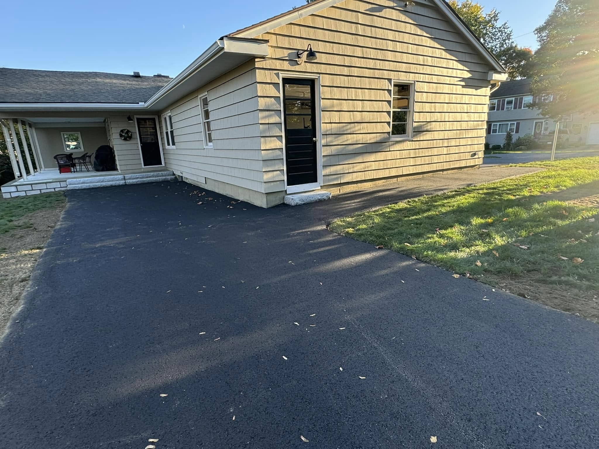 Freshly installed asphalt driveway at a residential home with smooth blacktop finish and clean edges