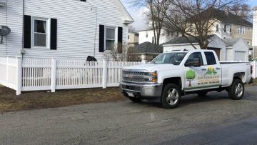 white vinyl fence installation for pet safety in residential yard with dog