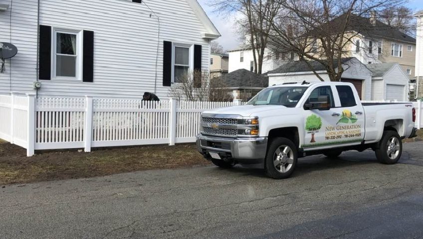 white vinyl fence installation for pet safety in residential yard with dog