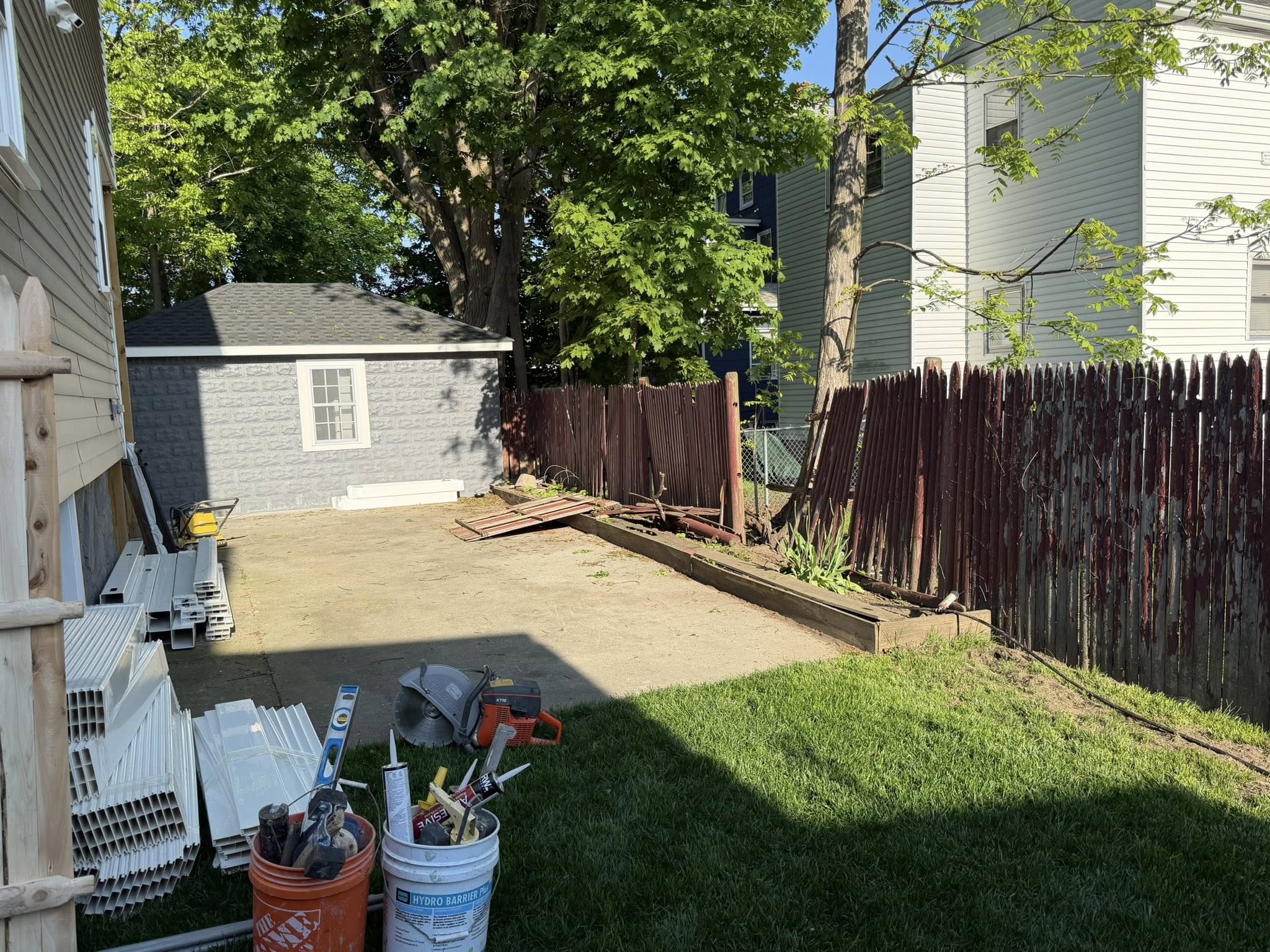 What to Expect During a Professional Fence Installation content image backyard fence installation project Backyard fence installation project with fencing materials and preparation work