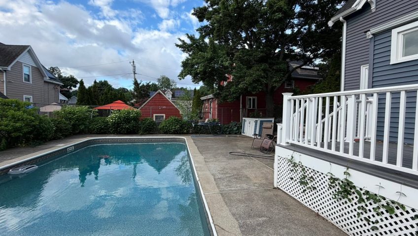 Residential swimming pool surrounded by privacy shrubs and outdoor living space designed for poolside landscape privacy screening.