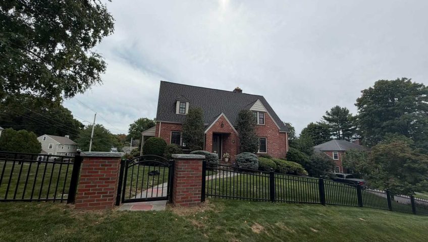 Front gate with black aluminum fence and landscaped lawn in Peabody MA