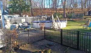 Seasonal Fence Installation: Best Times to Install or Repair Your Fence seasonal metal backyard safety fence installation Black metal backyard safety fence installation around outdoor living and pool area for seasonal durability and security