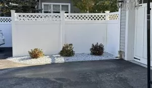 Seasonal Fence Installation: Best Times to Install or Repair Your Fence seasonal vinyl privacy fence installation driveway White vinyl privacy fence installation along residential driveway improving curb appeal and property boundary protection